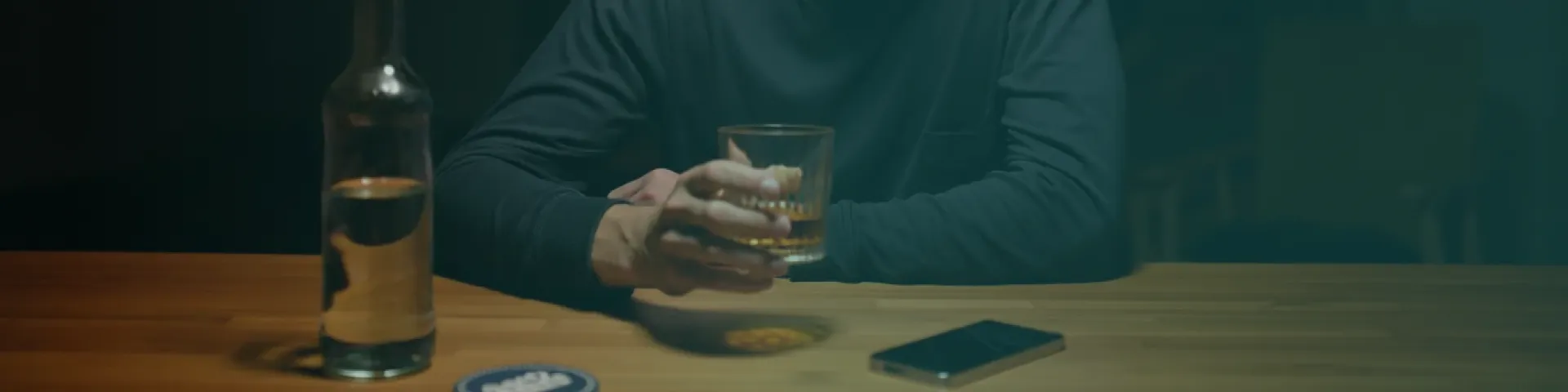 Человек с бутылкой алкоголя и стаканом